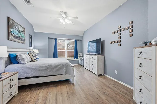 a spacious bedroom with a bed and a flat screen tv