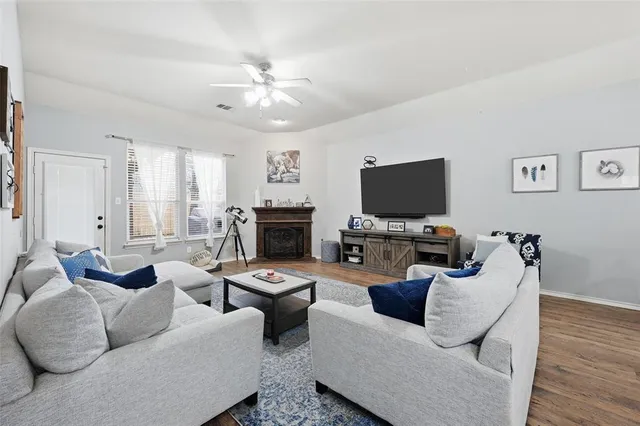 a living room with furniture a flat screen tv and a fireplace