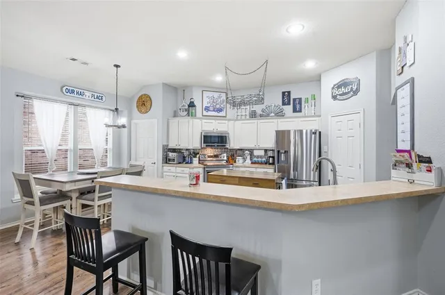 a kitchen with stainless steel appliances kitchen island granite countertop a sink and cabinets