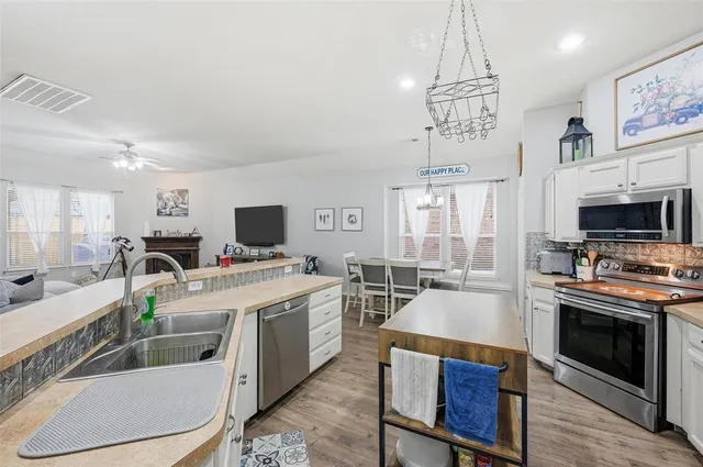 a large kitchen with a table chairs stove and flat screen tv