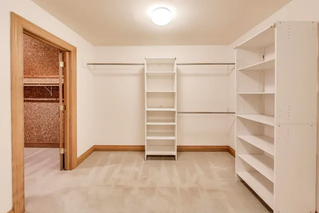 an empty room with chandelier fan and windows