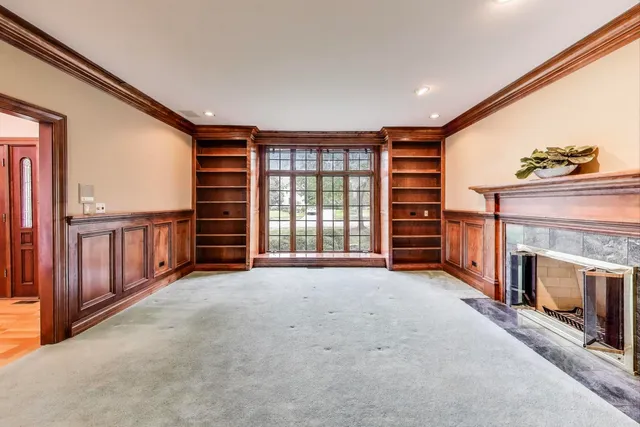 a view of an empty room with a fireplace and a window