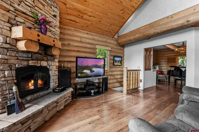 a living room with furniture a flat screen tv and a fireplace