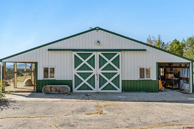 a sign board with a house in the background