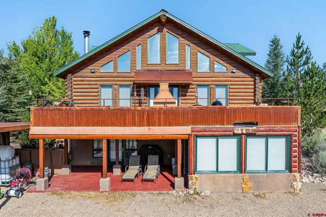 a view of a house with large windows and plants