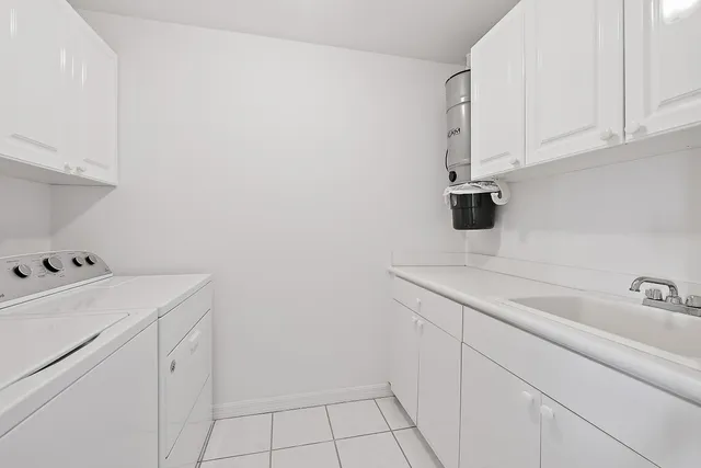 a utility room with cabinets washer and dryer