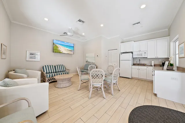 a living room with stainless steel appliances furniture and a wooden floor