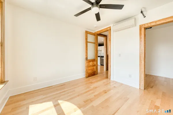 a view of a big room with wooden floor and a ceiling fan