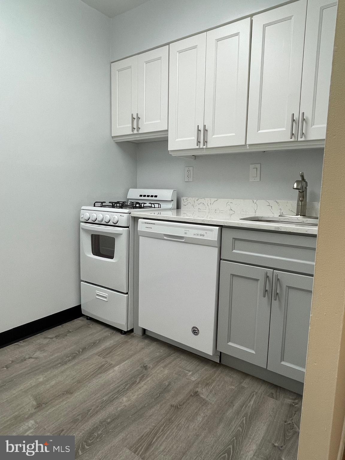 817 Delaware Avenue Southwest, Unit 227 Washington, DC 20024 - Photo 7 of 27 a kitchen with granite countertop white cabinets and sink