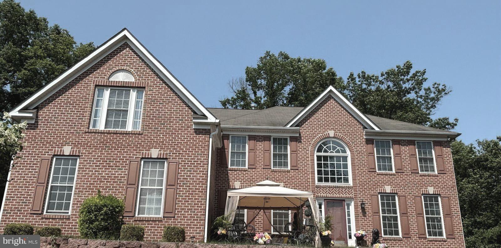 a front view of a house with yard and trees