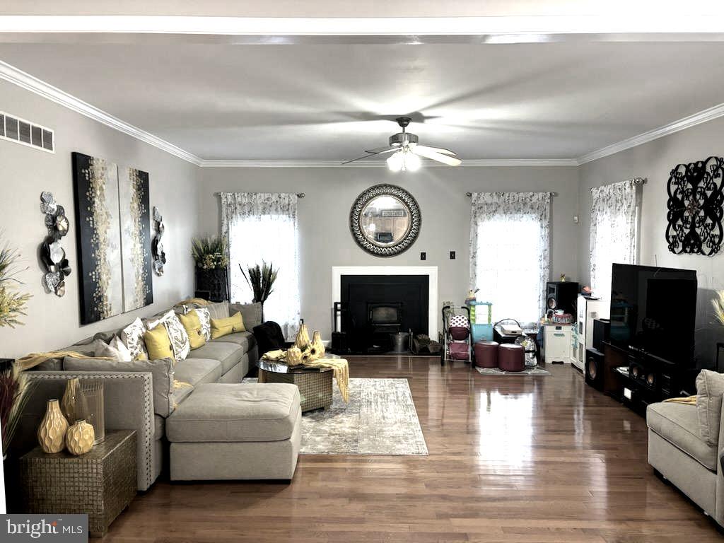 9319 Migan Road Randallstown, MD 21133 - Photo 4 of 32 a living room with furniture a clock and a flat screen tv