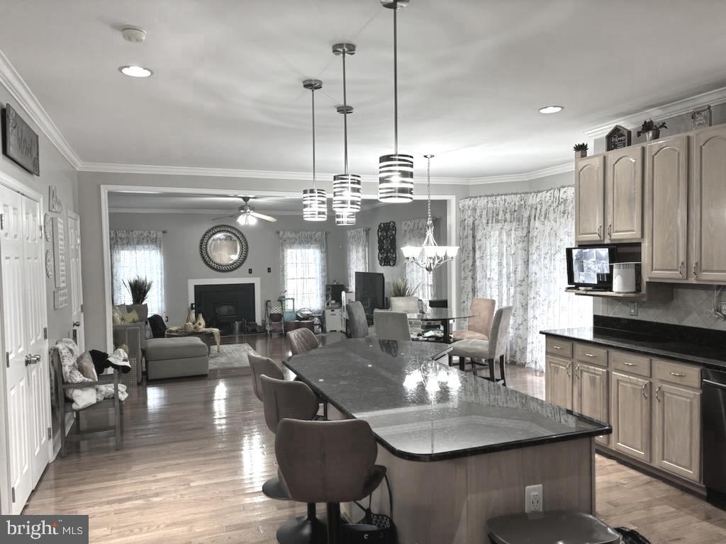 9319 Migan Road Randallstown, MD 21133 - Photo 8 of 32 a view of a dining room and livingroom with furniture wooden floor a chandelier