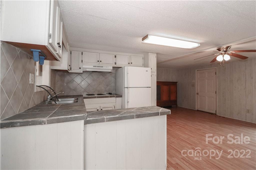 8785 Holdsclaw Road Terrell, NC 28682 - Photo 24 of 35 a kitchen with kitchen island a sink stainless steel appliances and a counter top space