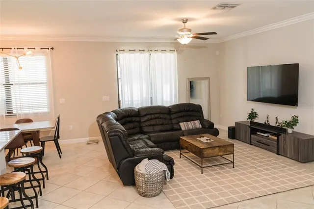 a living room with furniture a chandelier and a flat screen tv