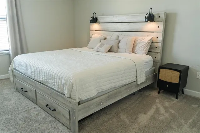 a bed sitting in a bedroom next to a window