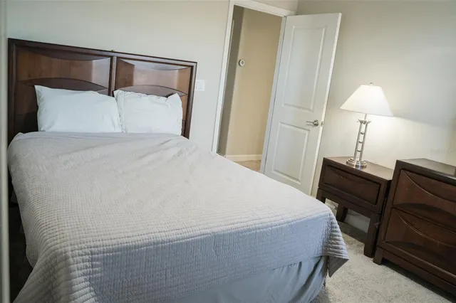 a bedroom with a bed and a lamp on dresser
