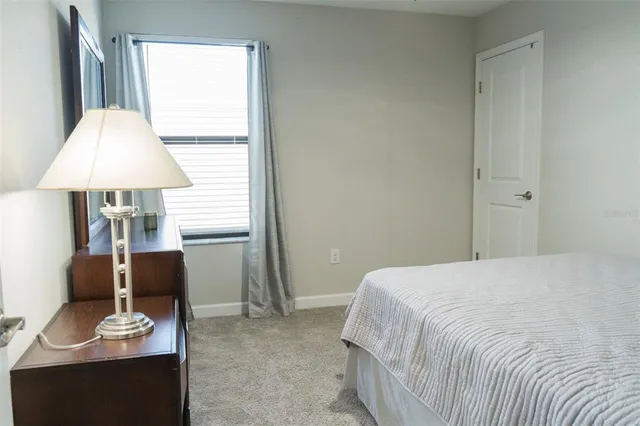 a bedroom with a bed and a lamp on dresser