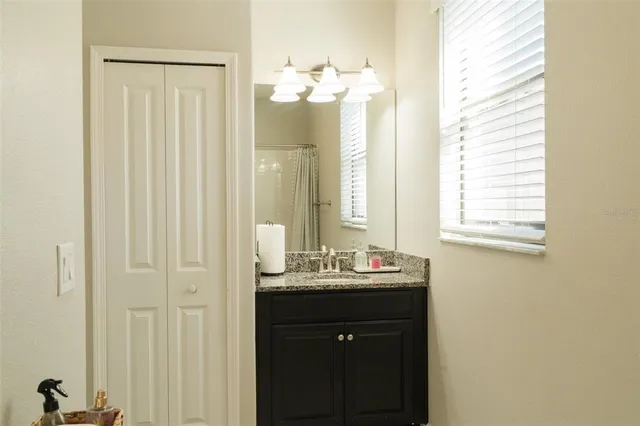 a bathroom with a sink mirror and a window