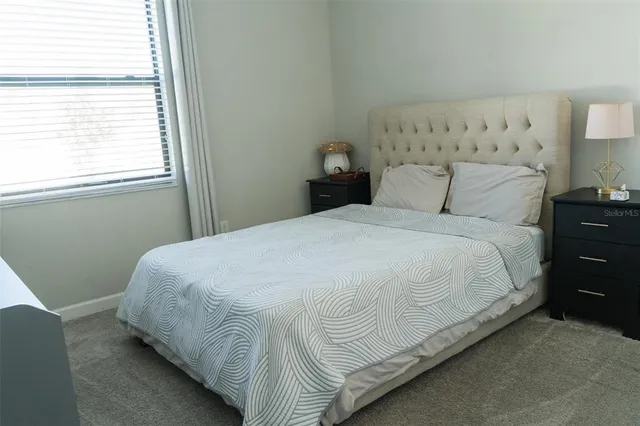 a large bed sitting in a bedroom next to a window
