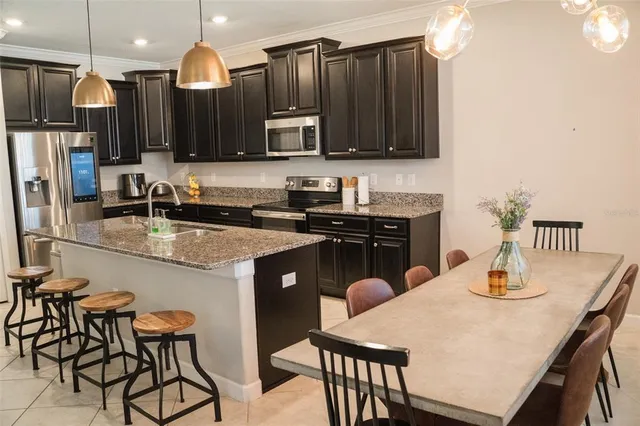 a kitchen with granite countertop a sink cabinets and stainless steel appliances
