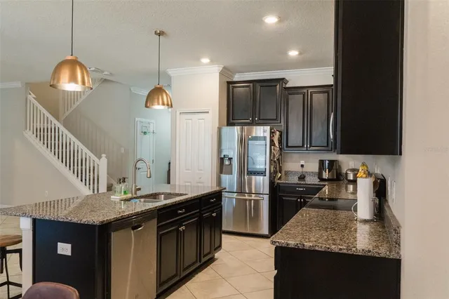 a kitchen with stainless steel appliances granite countertop a sink a stove and a refrigerator