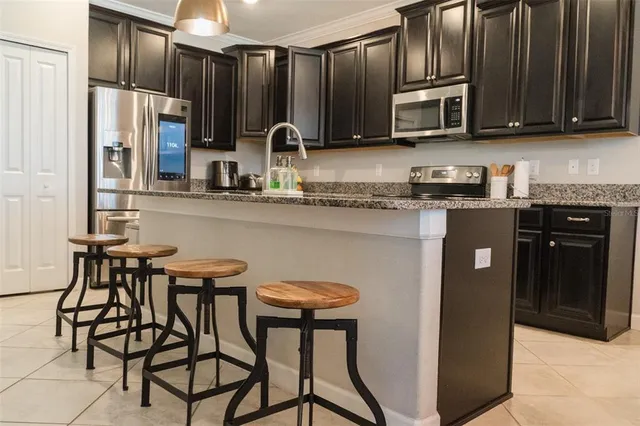 a kitchen with stainless steel appliances wooden cabinets a stove a sink and a microwave