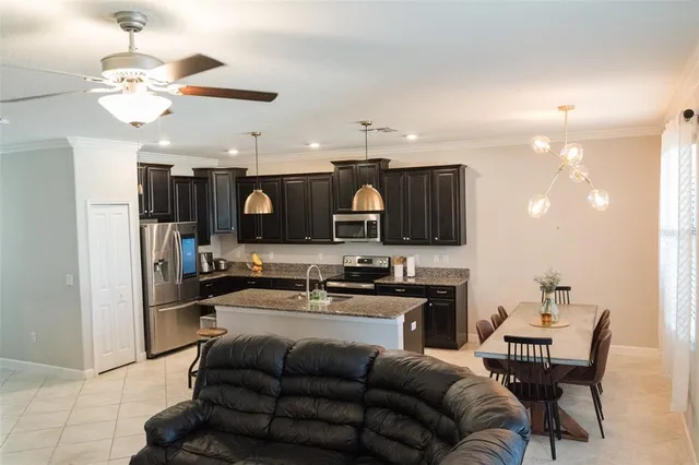 a living room with stainless steel appliances kitchen island granite countertop furniture and a view of kitchen