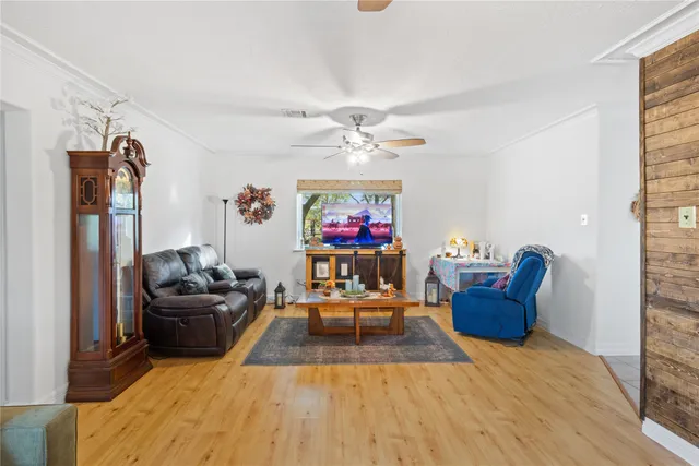 a living room with furniture a flat screen tv and a window