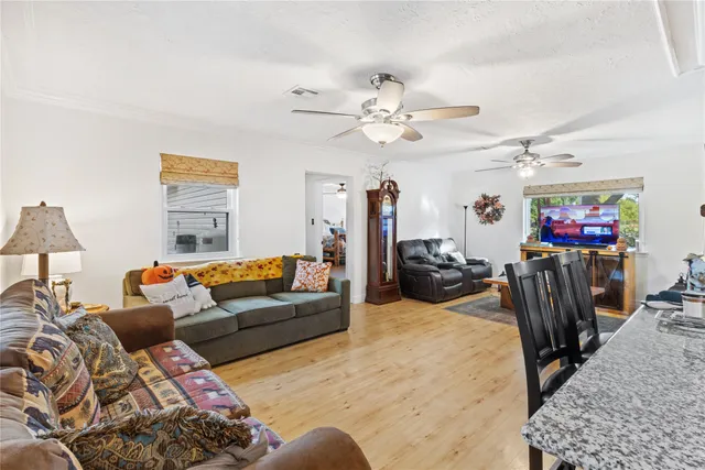 a living room with furniture a chandelier and a flat screen tv