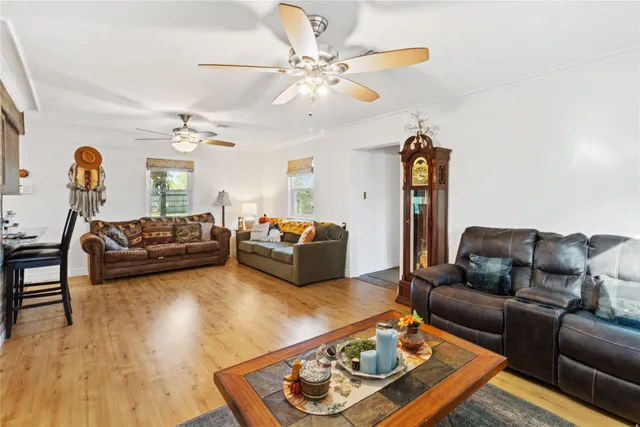 a living room with furniture ceiling fan and a wooden floor