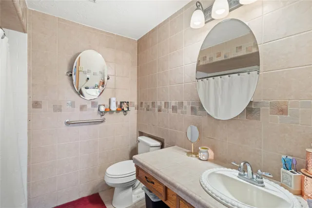 a bathroom with a sink mirror toilet and a mirror