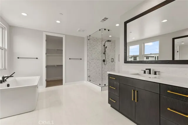a spacious bathroom with a bathtub shower sink double and mirror