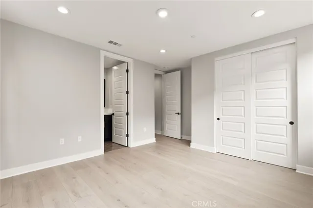 an empty room with closet and wooden shelves