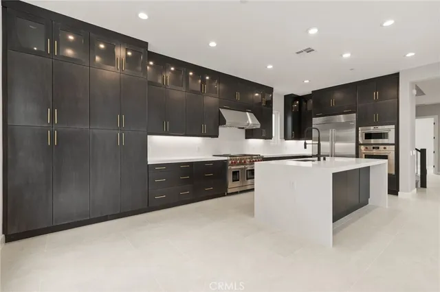 a large kitchen with a large counter top stainless steel appliances and cabinets