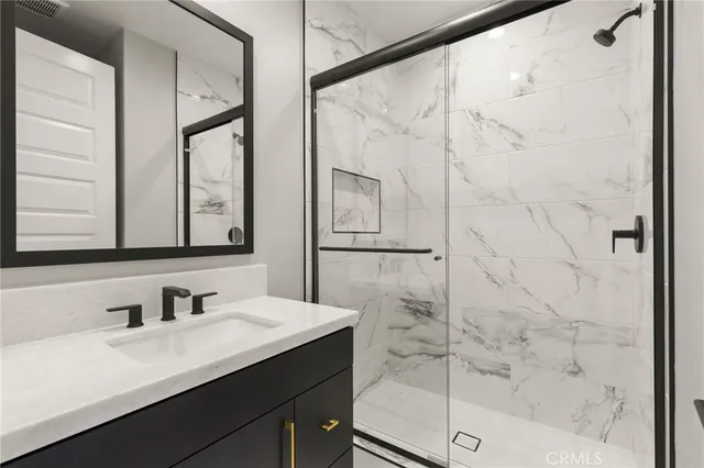 a bathroom with a shower sink and mirror