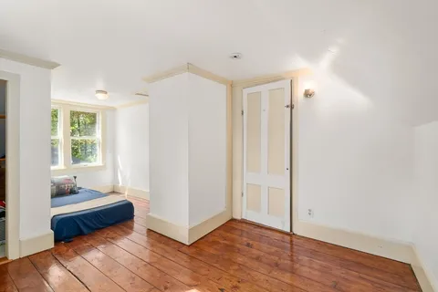 a view of a room with wooden floor and windows