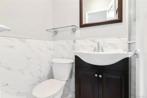 a bathroom with a sink toilet and mirror