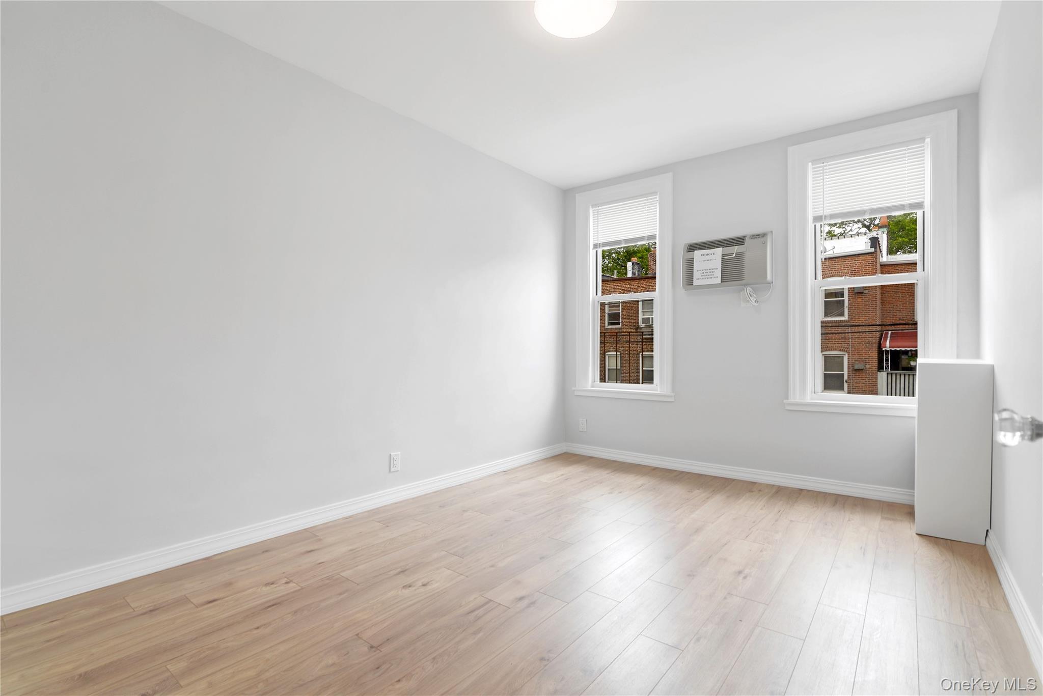 21-69 45th Street, Unit 3 Queens, NY 11105 - Photo 2 of 31 an empty room with wooden floor and windows