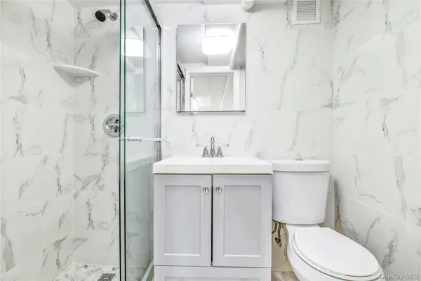 a bathroom with a sink a toilet and shower