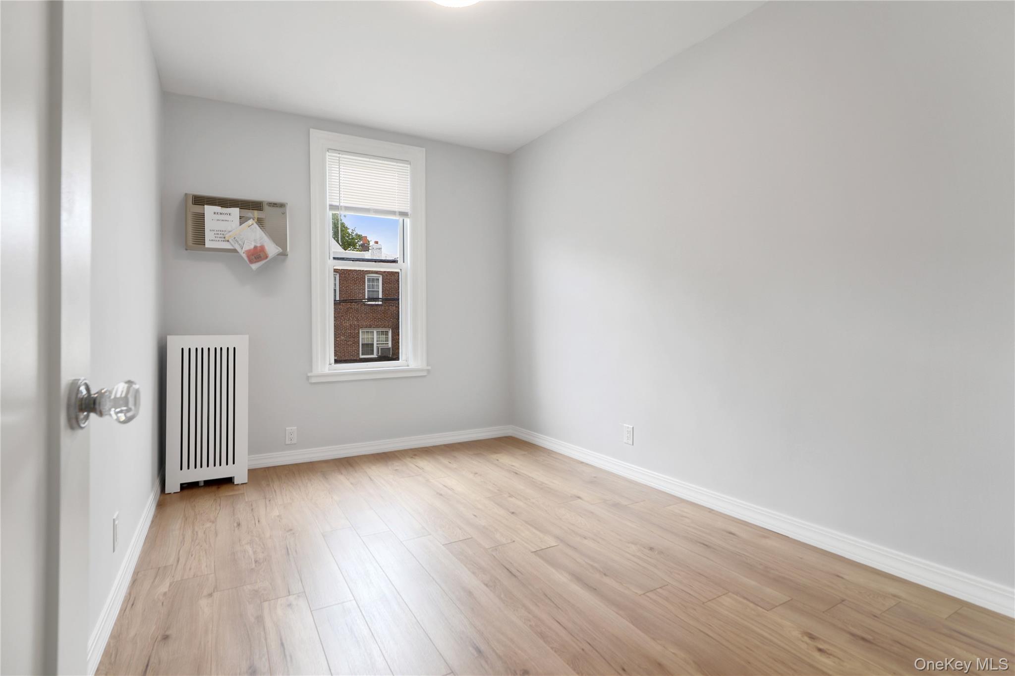 21-69 45th Street, Unit 3 Queens, NY 11105 - Photo 4 of 31 an empty room with wooden floor and windows
