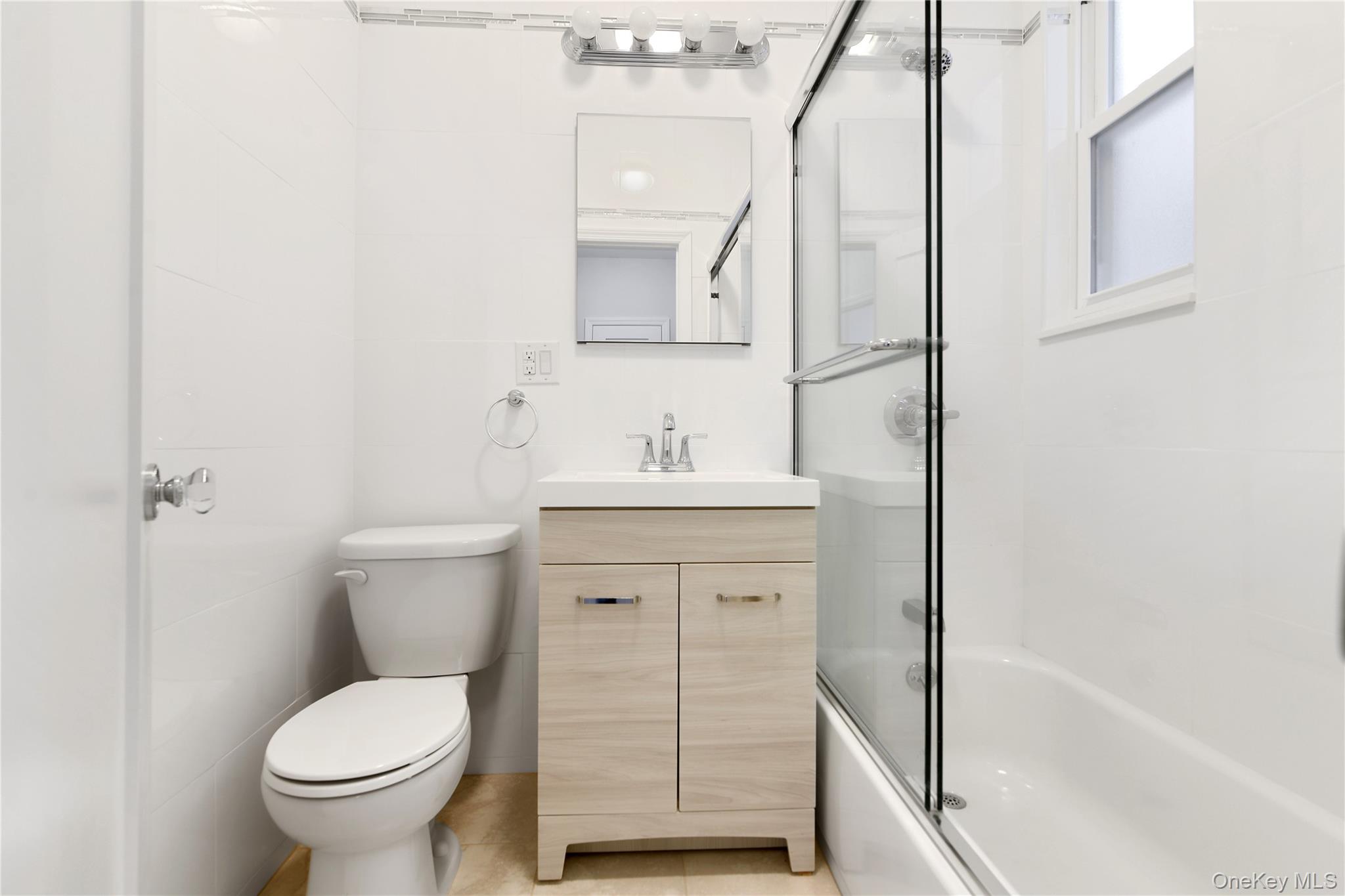 21-69 45th Street, Unit 3 Queens, NY 11105 - Photo 7 of 31 a bathroom with a toilet sink and a mirror
