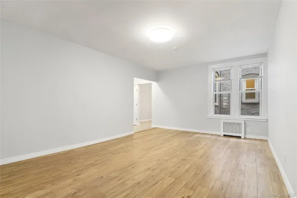 an empty room with wooden floor and a window