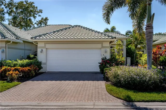 a front view of a house with a yard and potted plants