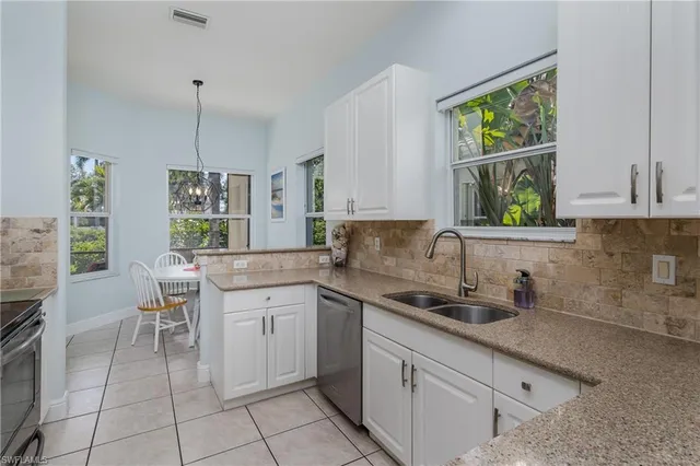 a kitchen with a sink window and cabinets