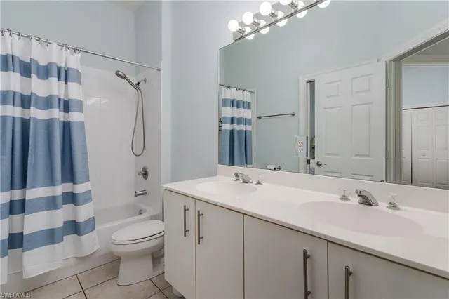 a bathroom with a sink a toilet a mirror a vanity and shower