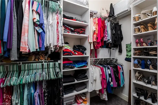 a view of walk in closet with clothes and shoes