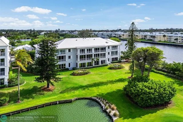 a view of a house with a big yard and large trees