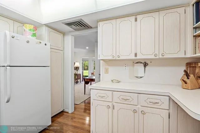 a kitchen with a refrigerator and white cabinets