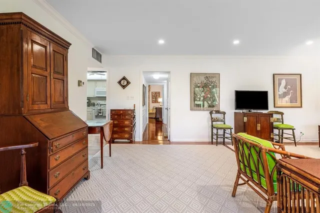 a living room with furniture a flat screen tv and kitchen view