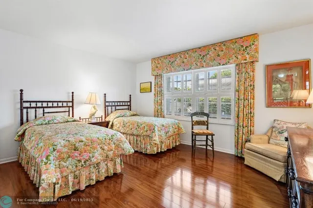 a bedroom with two beds and wooden floor
